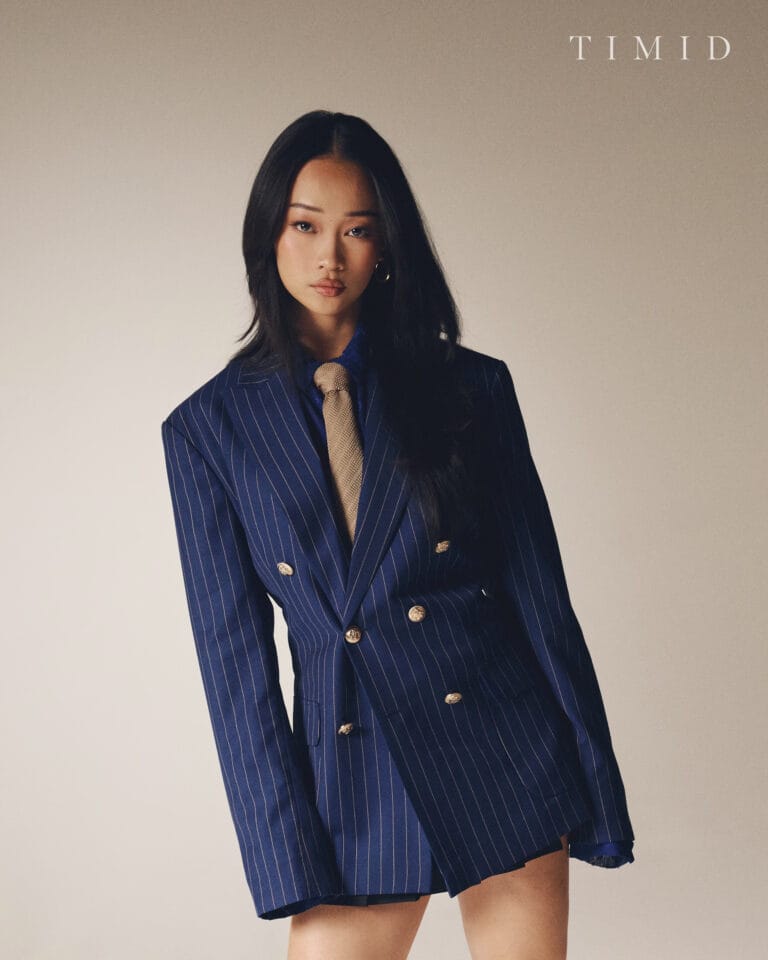 Callina Liang: Wears a navy blue pinstripe suit, oversized, that highlights her figure with…