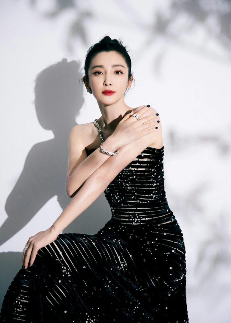 Li Bingbing: Luce un vestido negro ajustado con detalles brillantes que acentúan su figura. Está sentada,…