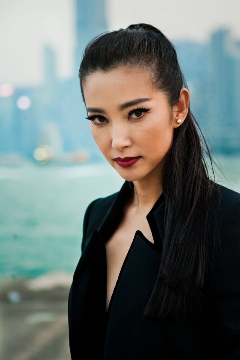 Li Bingbing: Luce un elegante abrigo negro con un corte asimétrico y un escote profundo, que…