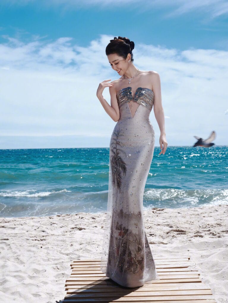 Li Bingbing: Luce un impresionante vestido strapless plateado con detalles brillantes, que se ajusta elegantemente a…
