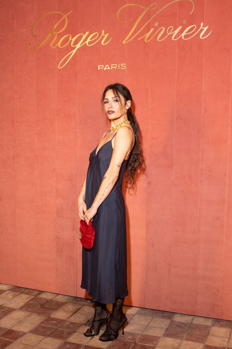 Sarah Shahi: Luce un vestido largo negro con tirantes finos, que resalta su figura con elegancia.…
