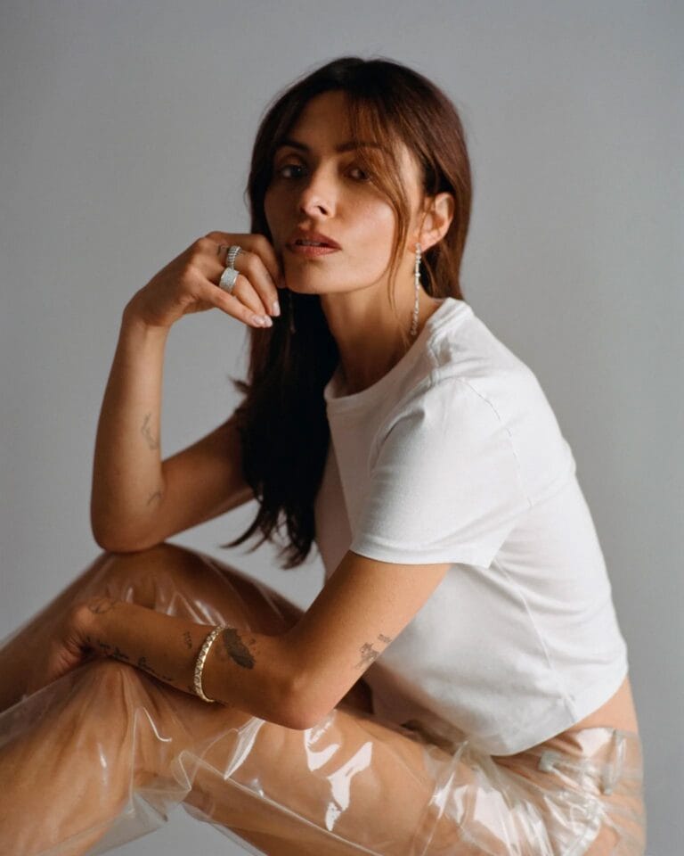 Sarah Shahi: Luce una camiseta blanca ajustada, combinada con pantalones transparentes que resaltan su figura. Apoya…