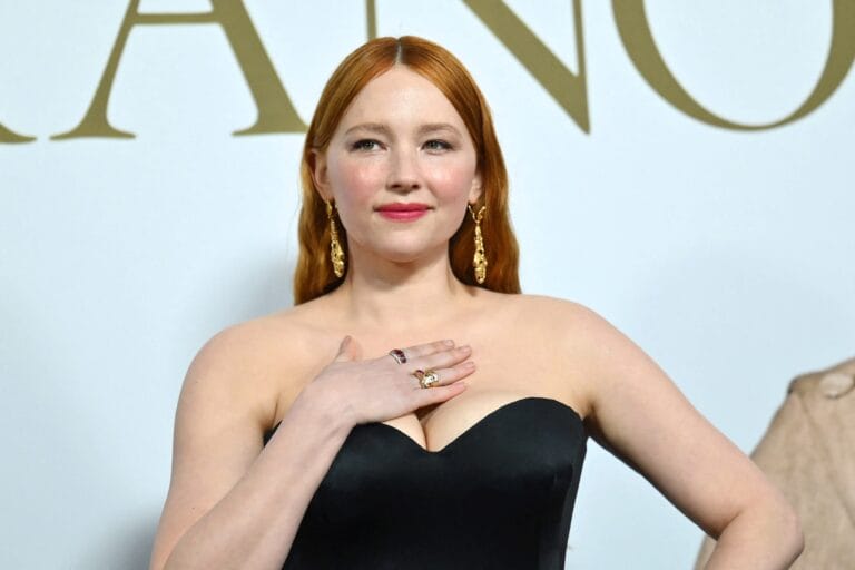 Haley Bennett: Luce un vestido negro strapless que resalta su figura, con un escote elegante. Sostiene…