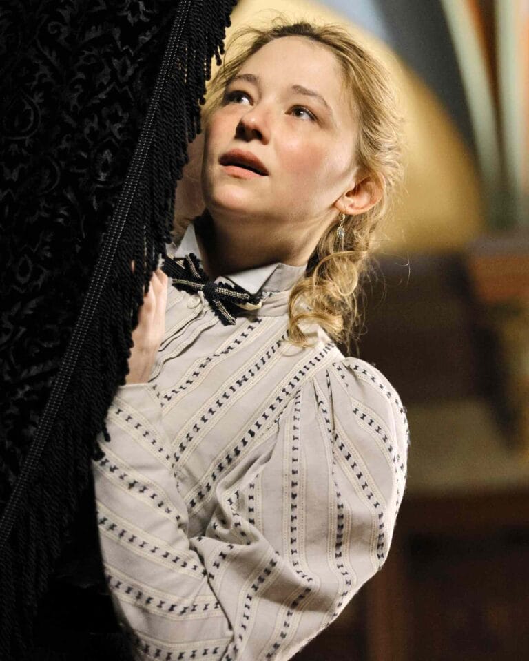 Haley Bennett: Aparece en un entorno vintage, sosteniéndose de una cortina oscura mientras mira hacia arriba…