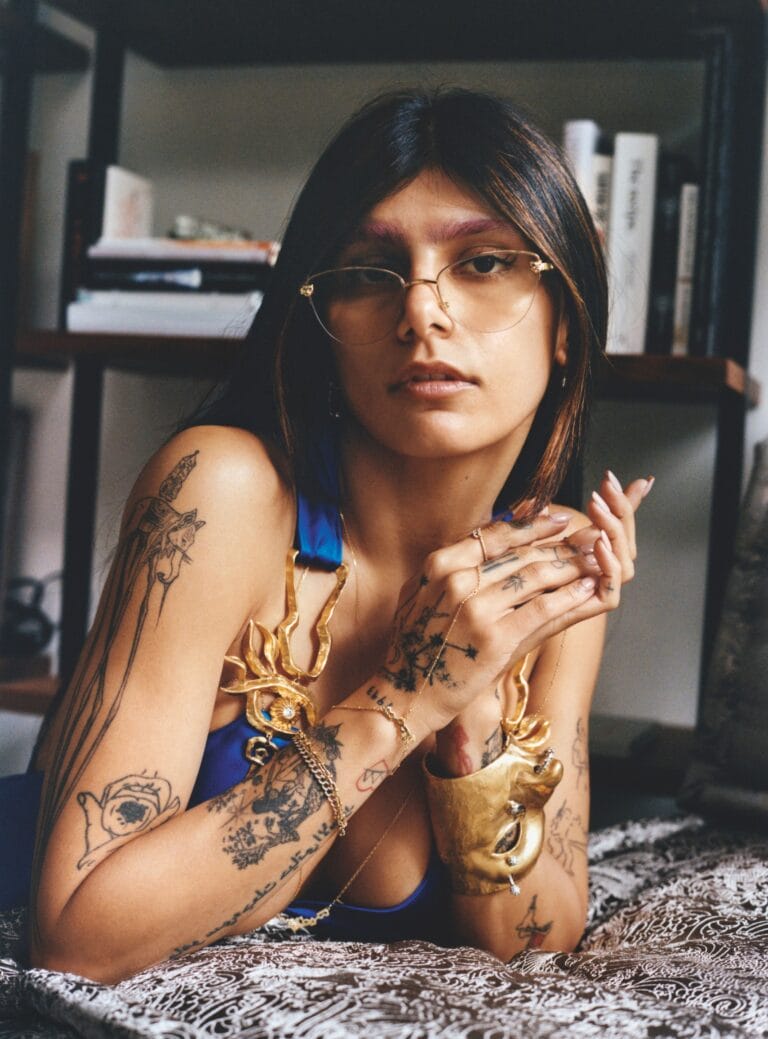 Mia Khalifa: Luce un top azul vibrante que resalta su figura, adornado con joyería dorada que…