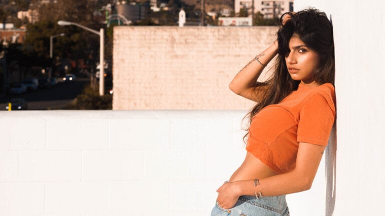 Mia Khalifa: Luce una camiseta corta de color naranja que resalta su figura, combinada con jeans…