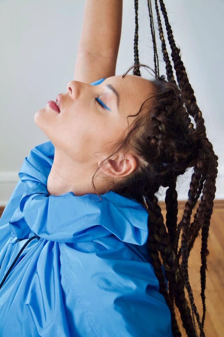 Jasmine Cephas Jones: Luce un abrigo azul brillante con un cuello voluminoso, mientras su cabello trenzado cae…