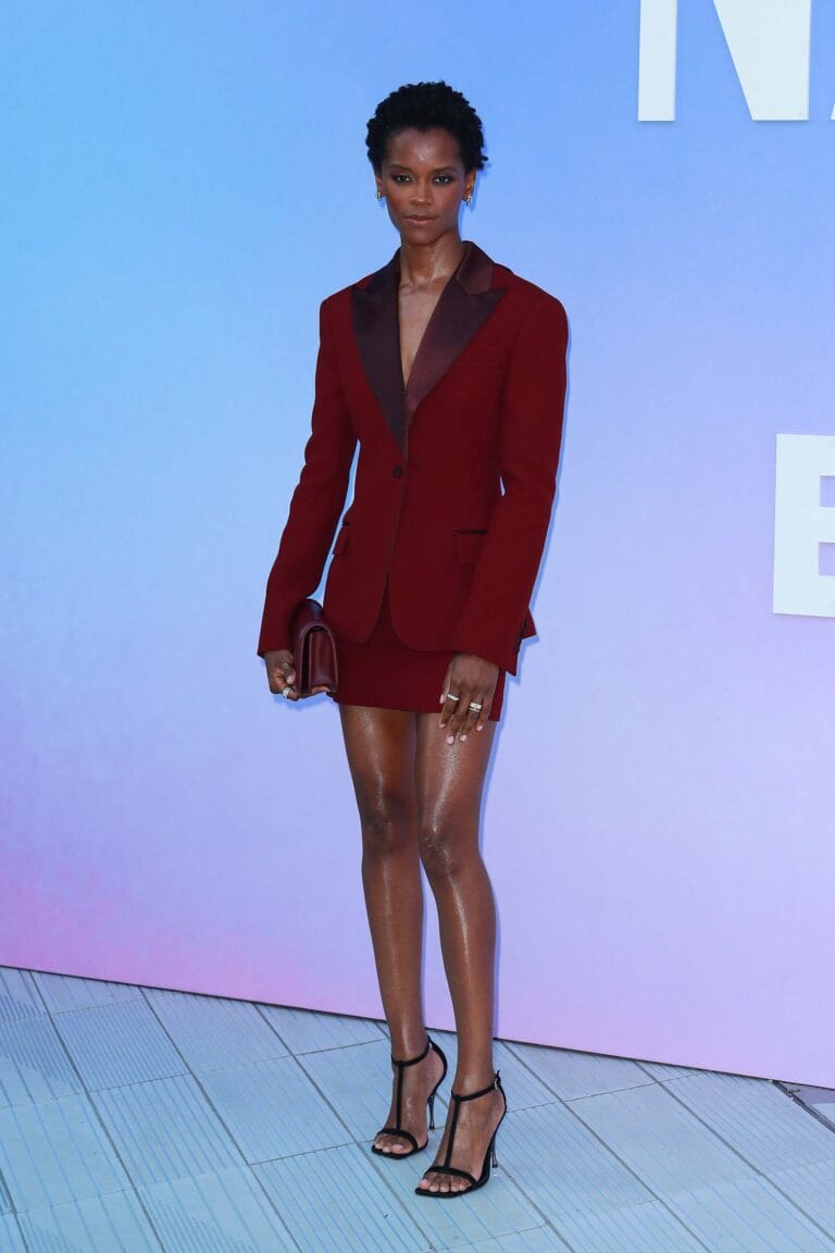 Letitia Wright: Luce un conjunto de blazer y mini falda en un profundo tono burdeos, con…