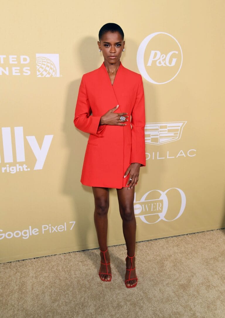 Letitia Wright: Luce un vestido corto rojo con un corte elegante y moderno, destacando su figura.…