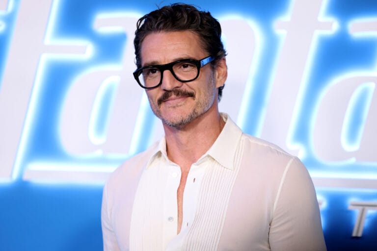 Pedro Pascal: Luce una camisa blanca de corte elegante con detalles pliegues, complementada por unas gafas…