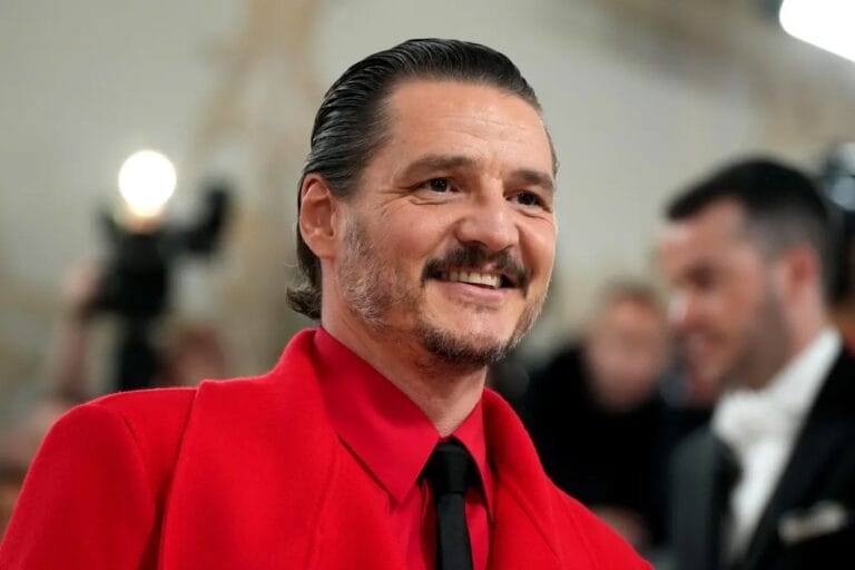 Pedro Pascal: Luce un traje rojo vibrante con una camisa negra y corbata que resalta su…