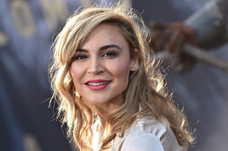 Samaire Armstrong: Luce una blusa satinada de color claro, con un corte elegante que resalta su…