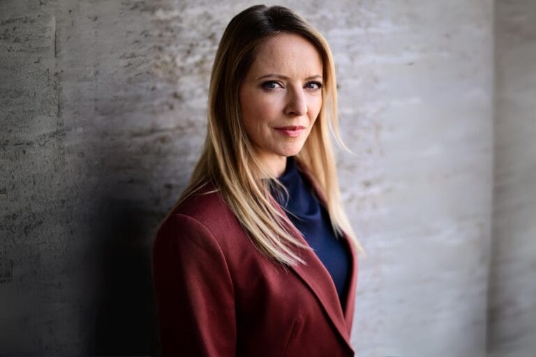 Diana Staehly: Luce un elegante blazer burdeos sobre una blusa azul oscuro, con un estilo sofisticado…