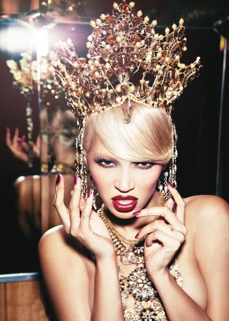 Beyoncé: Luce una imponente tiara dorada adornada con piedras brillantes, que resalta su actitud desafiante.…