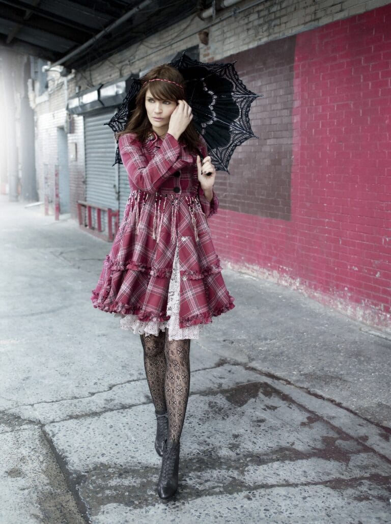 Helena Christensen: Wears a red plaid dress with ruffles, paired with a lace blouse that…