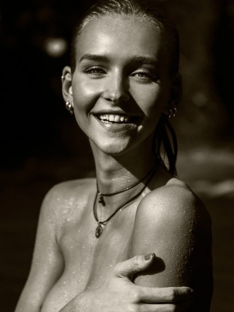 Rachel Cook: Luce una expresión radiante mientras se abraza suavemente el hombro, con el agua brillando…