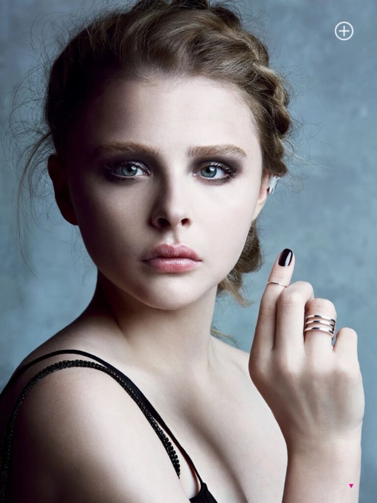 Chloë Grace Moretz: Wears a black top with thin straps that highlights her fair skin in a…