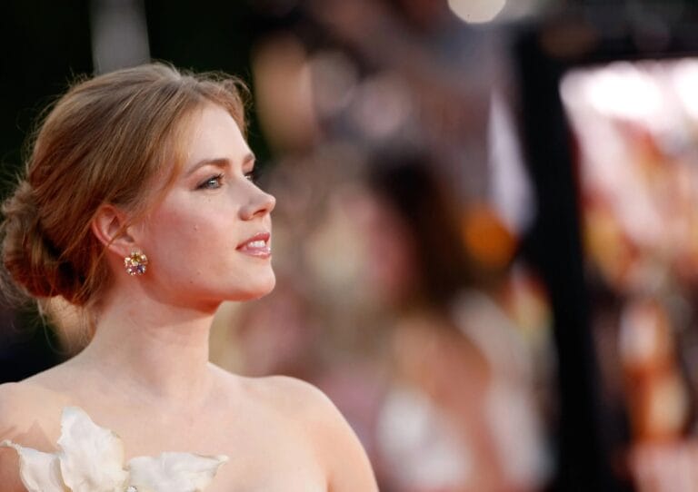 Amy Adams: Luce un vestido sin mangas con un delicado adorno floral en el hombro, destacando…