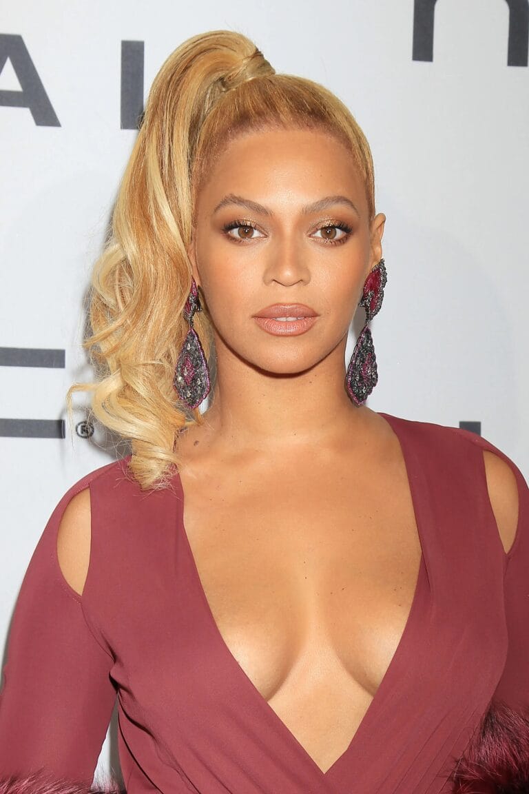 Beyoncé: Luce un vestido burdeos con un profundo escote en V, donde destacan detalles de…